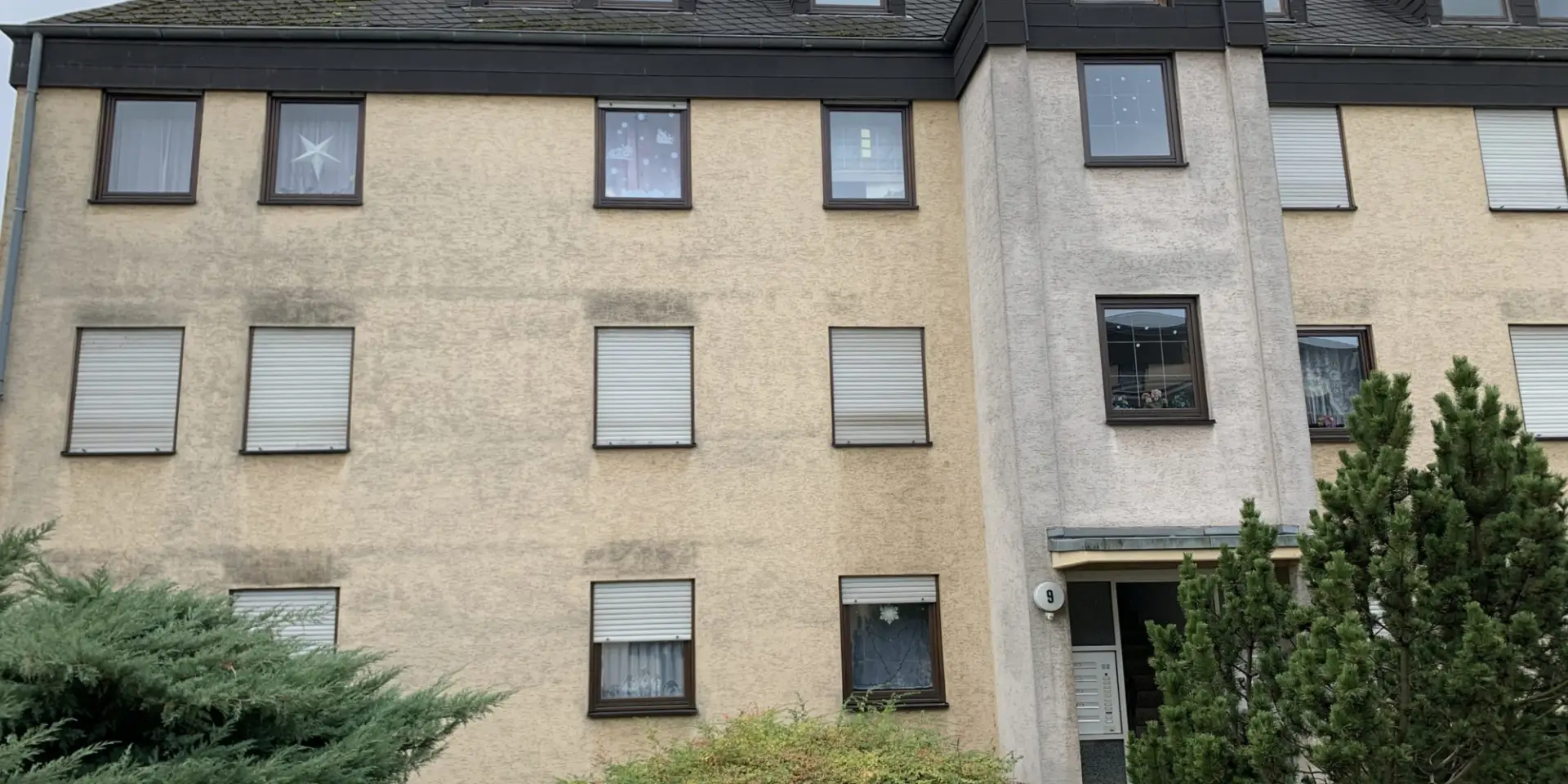 Fassadenreinigung Mehrfamilienhaus vor der Reinigung der Fassade | 80 % sparen im Vergleich zu Neuanstrich | 10 Jahre wie neu gestrichen